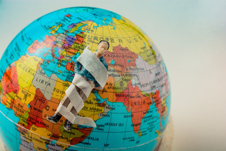 Tiny figurine of man  model wrapped in bandages  on earthの写真素材