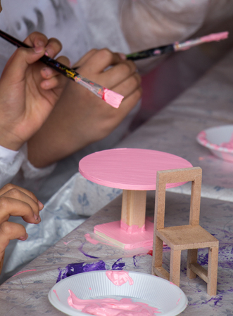 Young children decorating handmade wooden tableの写真素材
