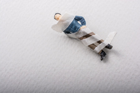 Tiny figurine of man miniature model wrapped in bandagesの写真素材