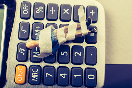 Tiny figurine of man model wrapped in bandages calculatorの写真素材