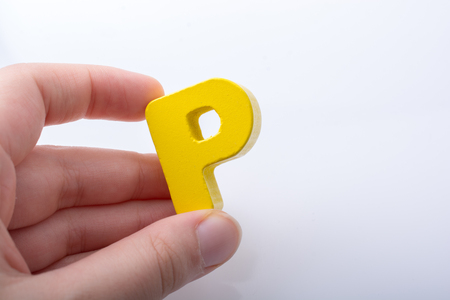 Hand holding letter cube P of made of woodの写真素材