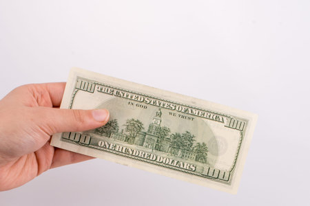 Hands holding American dollar banknotes and Turksh Lira banknotes side by side on white background