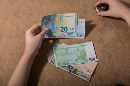 Hand holding American dollar  banknotes isolated on wooden backgroundの写真素材