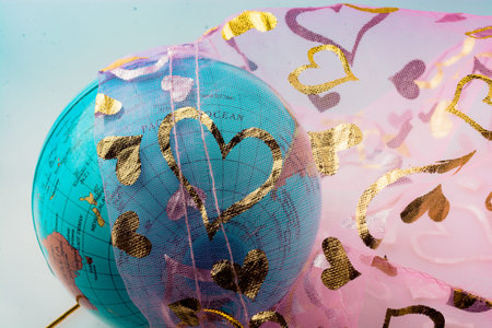 Little model globe under a fabric with heart patterns