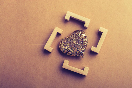 Gold color heart shaped  decorative object in brackets in view