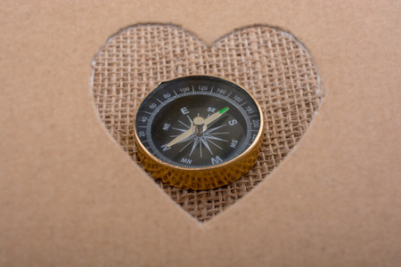 Compass as  instrument through a heart shaped holeの写真素材