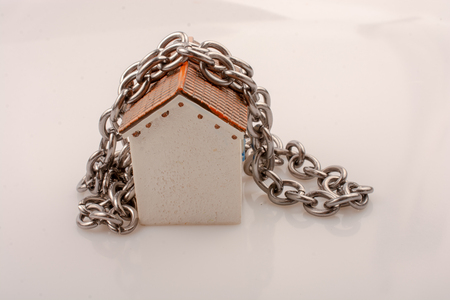 Chain around a little model house in the viewの写真素材