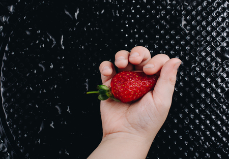 Juicy, sweet and ripe strawberry fruit in handの写真素材