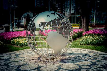 Little model globe made of metal in the  gardenの写真素材