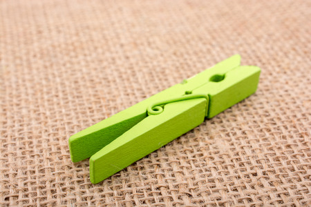 Green wooden clothespin on a textured background on displayの写真素材