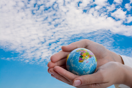 Hand holding a little model  globe  in the handの写真素材