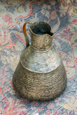 Ancient metal jug in oriental style  in antique marketの写真素材