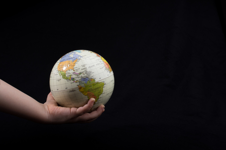 Hand holding a globe  with map on itの写真素材