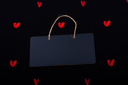Rectangular shaped black notice board  and red hearts on black backgroundの写真素材
