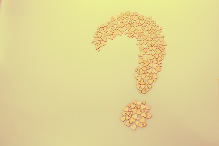 Wooden hearts form a question mark on a white backgroundの写真素材