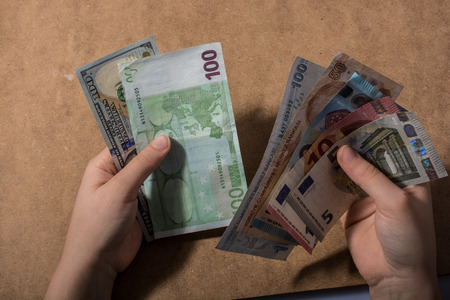Hand holding American dollar  banknotes isolated on wooden backgroundの写真素材