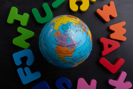 Earth globe model on colorful letters on a black backgroundの写真素材