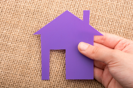 Hand holding a aper house on a canvas backgroundの写真素材
