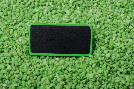 Hand holding noticeboard  on green color sandの写真素材