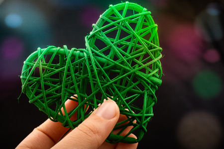 Handmade straw heart or valentines day object in handの写真素材