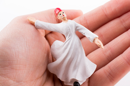 Hand holding a Sufi DerviÅ on a white backgroundの写真素材