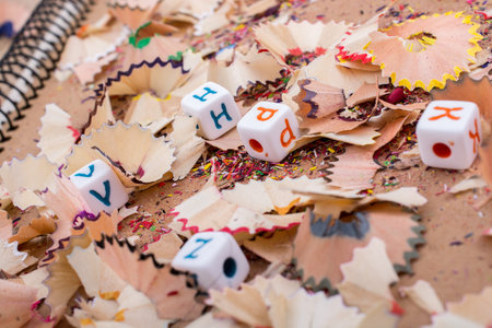 Colorful alphabet letter cubes on pencil trash