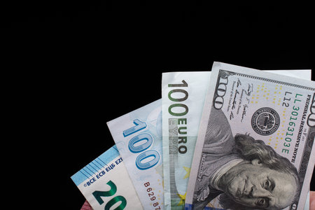 Hand holding American dollar  banknotes isolated on black background