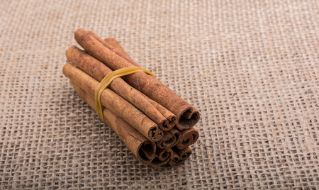 bundle of cinnamon sticks on a linen canvas  backgroundの写真素材
