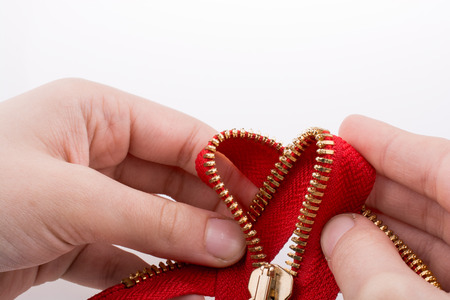 Hand holding color zipper on a white backgroundの写真素材