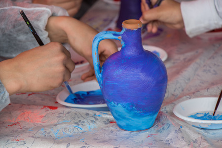 Young children decorating their handmade clay potteryの写真素材