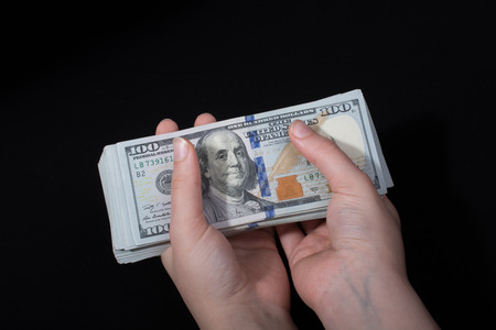 Hand holding American dollar  banknotes isolated on white backgroundの写真素材