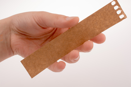 Hand holding a piece of paper on a white backgroundの写真素材