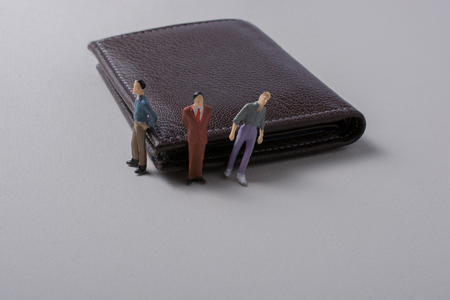 Tiny figurine of men miniature model beside a walletの写真素材