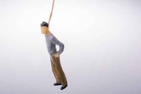 Man  figurine tied  with aa rope on a brown backgorundの写真素材