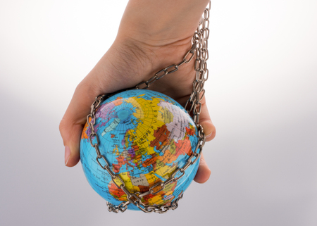 Globe in chain on a whiteの写真素材