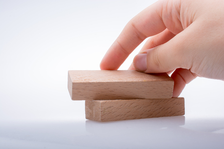 Hand holding wooden block on a whiteの写真素材
