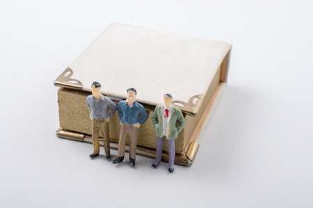 Tiny figurine of men models found beside a bookの写真素材