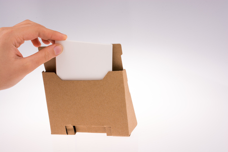 Hand reaches paper holder stand on white backgroundの写真素材