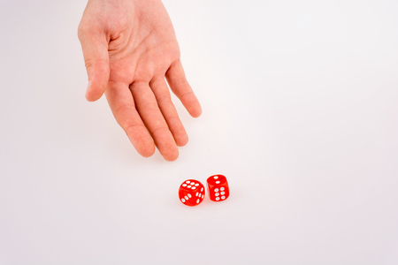 Hand holding red dice on a white backgroundの写真素材