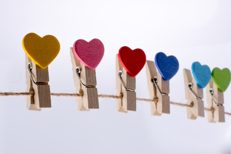Colorful hearts on clips hang on a thin ropeの写真素材