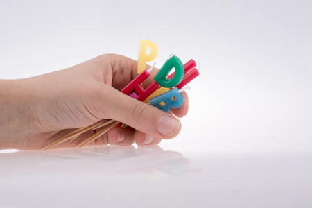 Hand holding  letters made of candles on sticksの写真素材