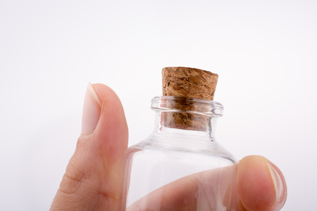 Little perfume glass bottle in hand on a white backgroundの写真素材