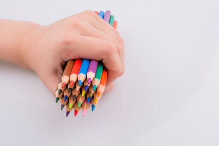 Hand holdin color pencils on a white backgroundの写真素材