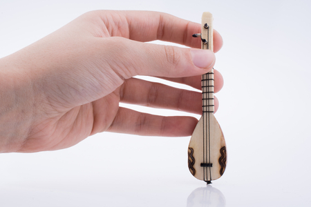 Hand holding turkish musical instrument saz on a white backgroundの写真素材