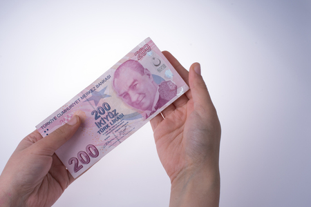 Hand holding Turksh Lira banknote  on white backgroundの写真素材