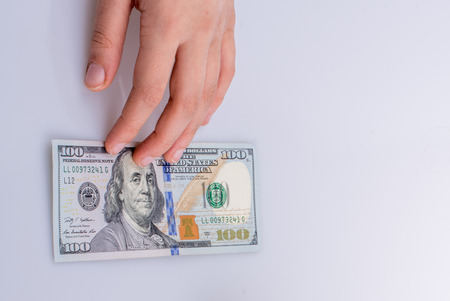 Hands holding American dollar banknotes and Turksh Lira banknotes side by side on white backgroundの写真素材