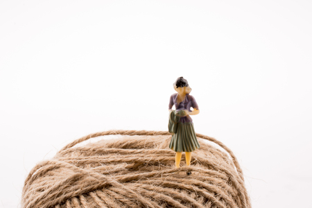 Woman figure with alinen spool of thread on a white backgroundの写真素材