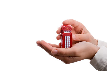 Telephone booth in hand on a white backgroundの写真素材