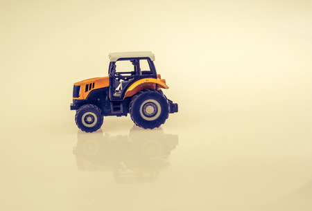 A miniature toy tractor on a white backgroundの写真素材