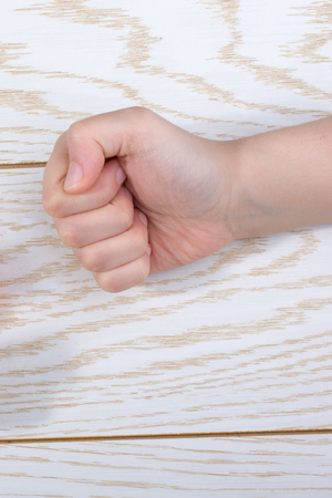 Hands making rock, paper, scissors gesture on a woodenの写真素材